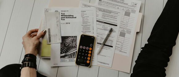 Taschenrechner und Unterlagen zur Baufinanzierung